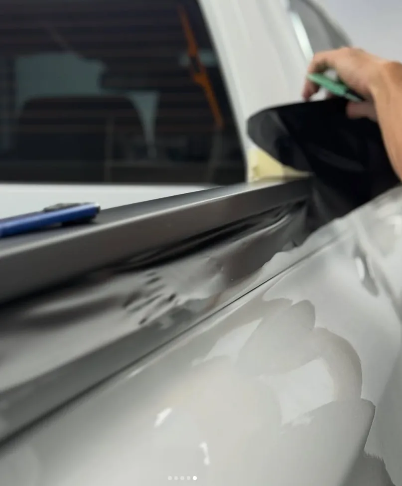 Detalle de aplicación de lámina negra en una camioneta blanca